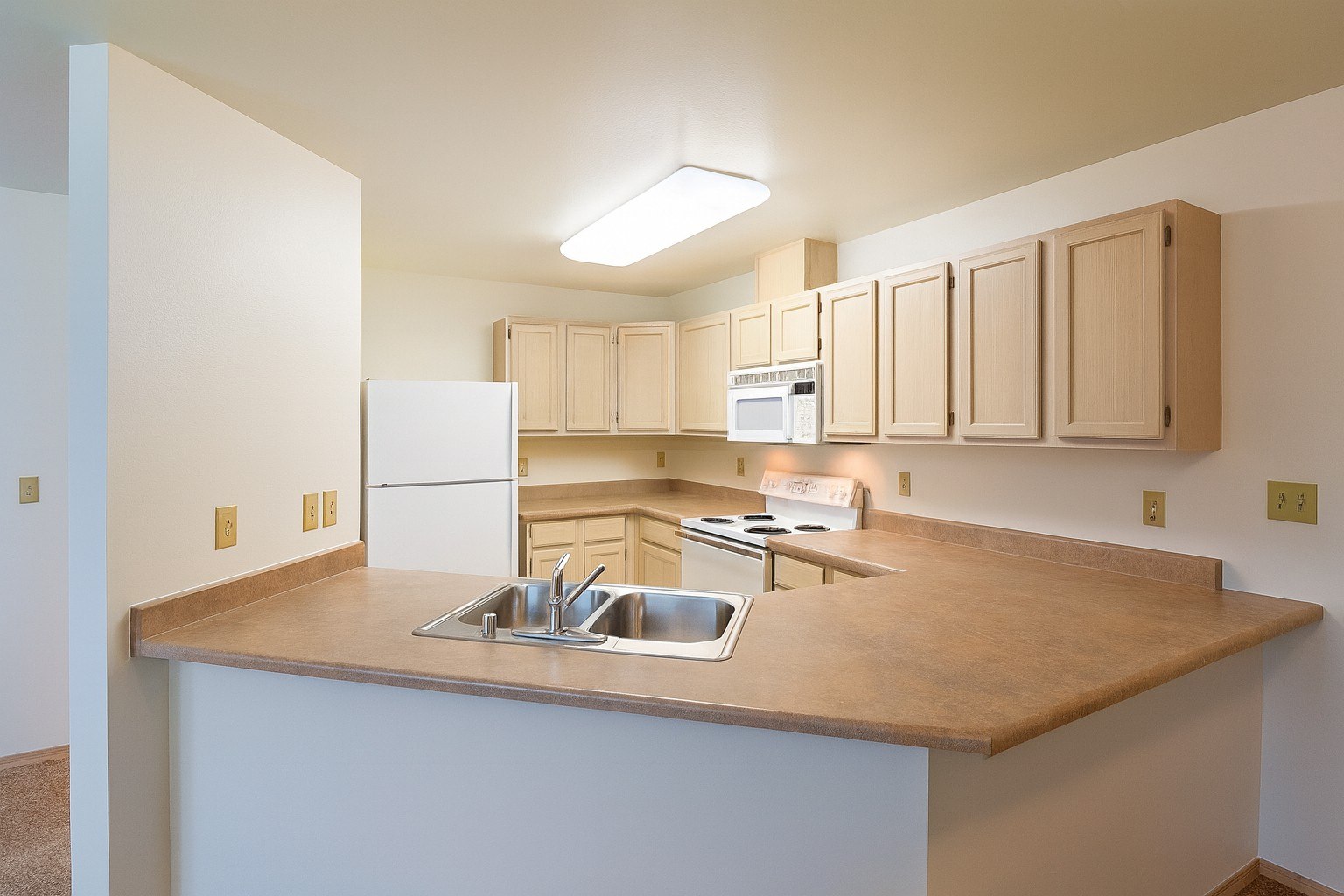 A kitchen with a white counter and a sink.